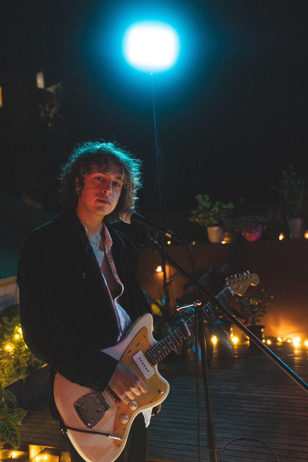 Scout Eastment of EGOISM holding her guitar and looking toward the microphone.