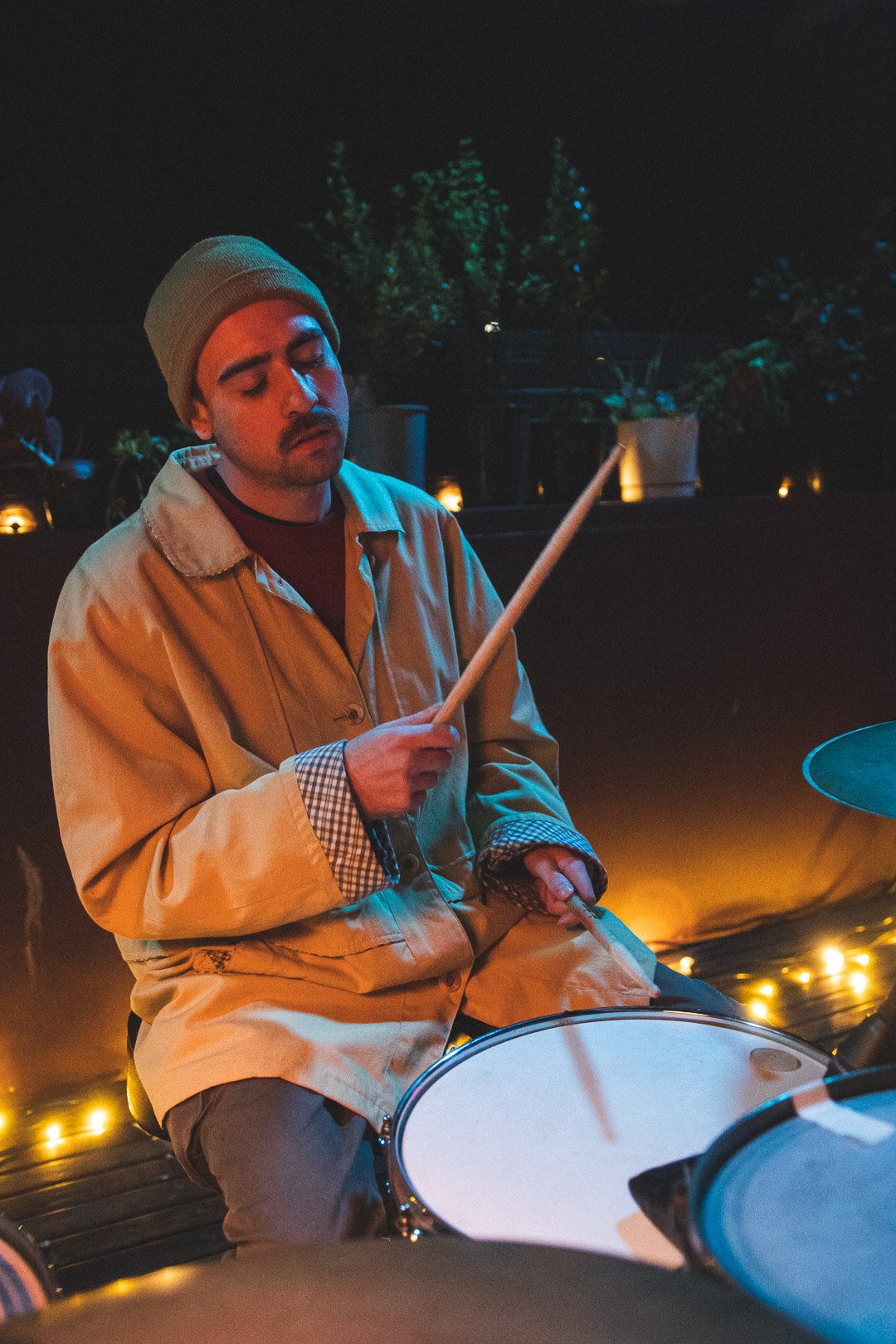 Adam Holmes of EGOISM seated behind kit playing rooftop live set