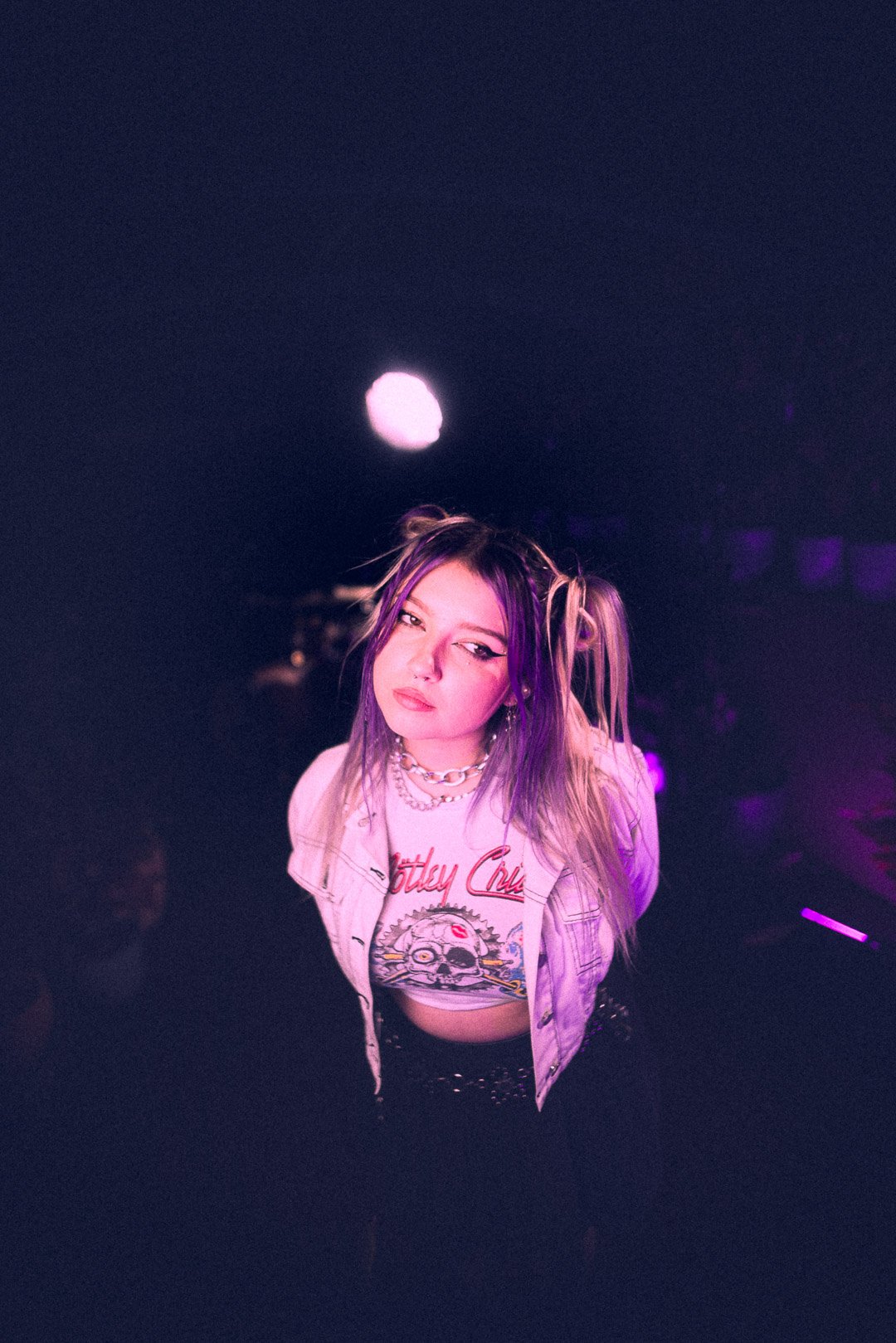 Ūla gazing offstage under soft purple lighting.