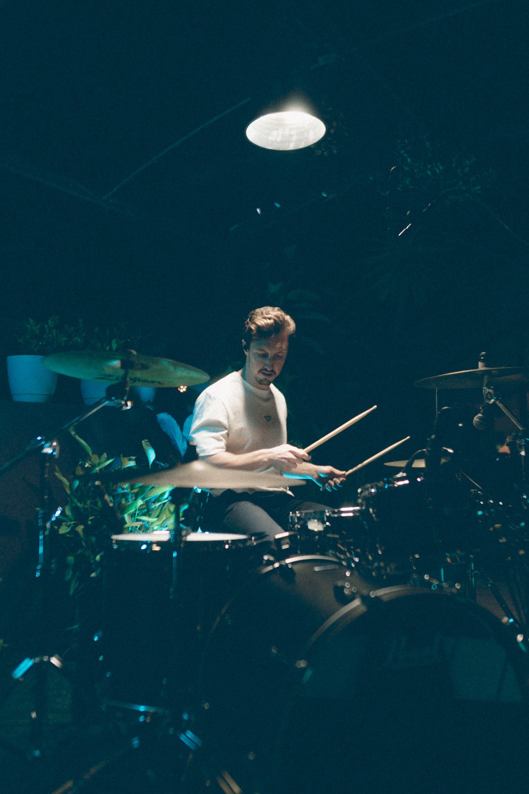 SAFIA drummer viewed from above playing acoustic drum kit.