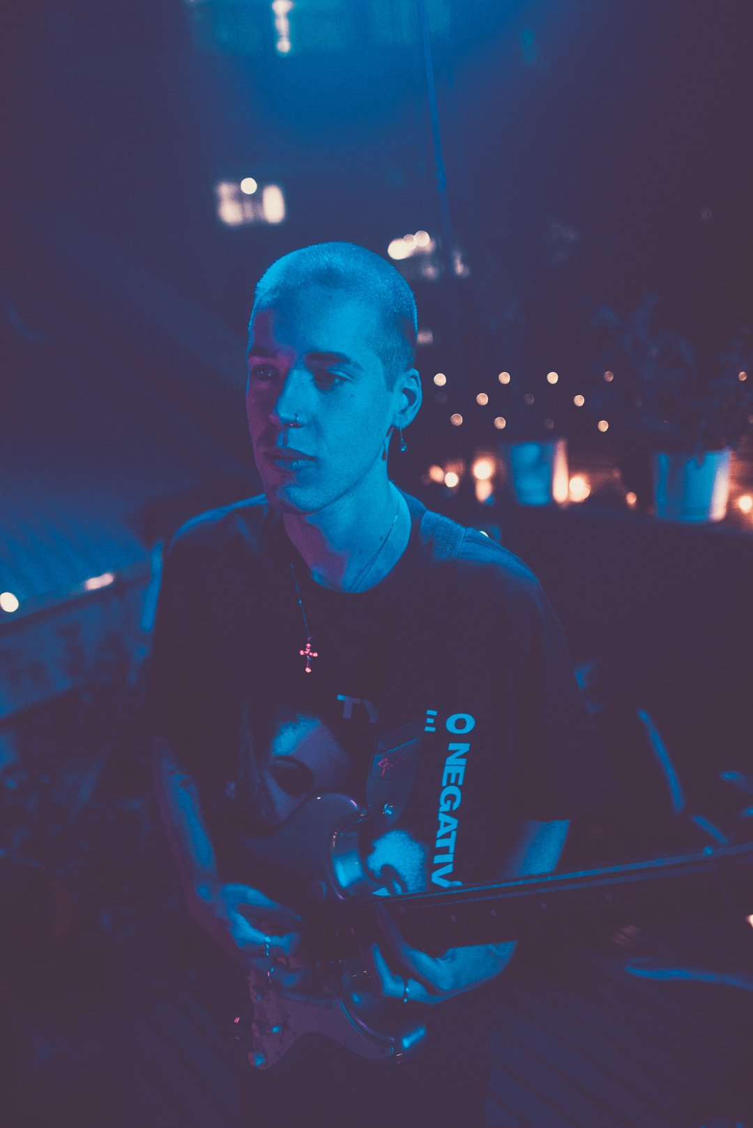 Session guitarist playing electric guitar under blue lighting on Mood on the Roof.