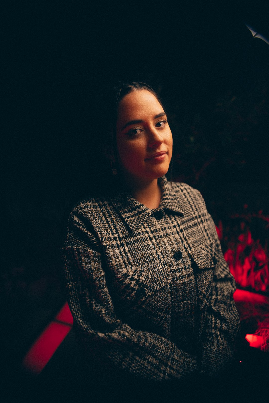 Tia Gostelow portrait between songs with soft red stage lighting.