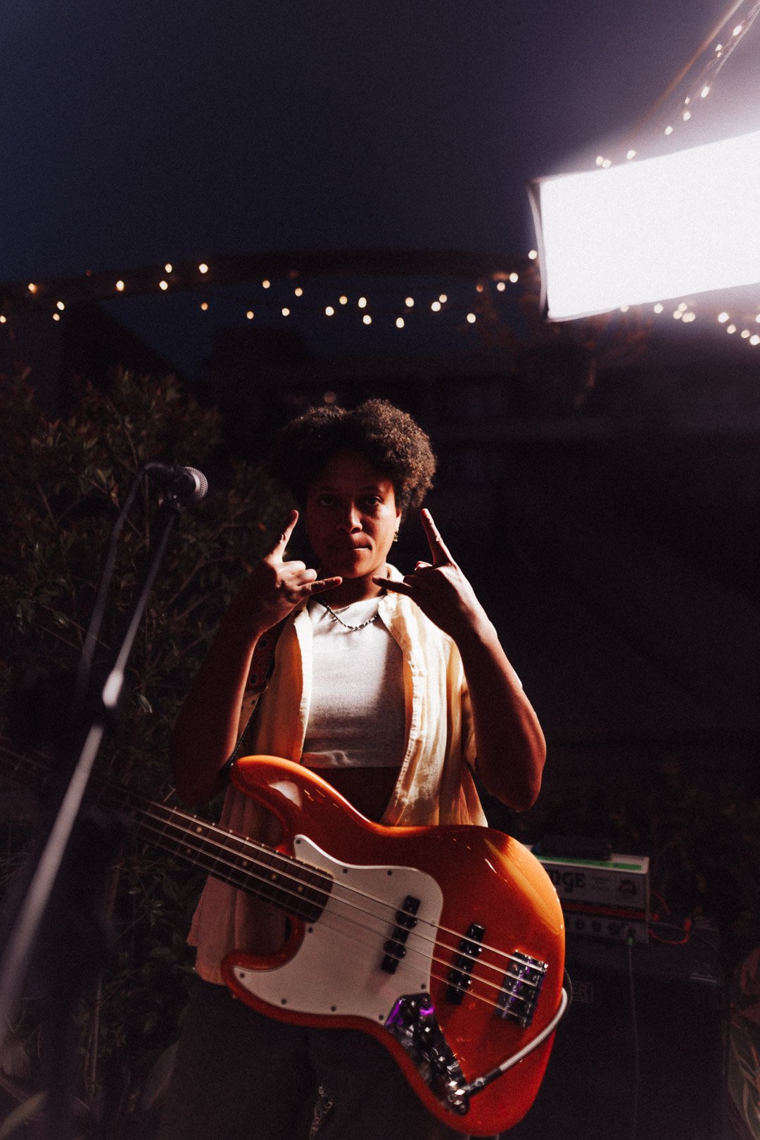 The Buoys bass player holding a bass guitar and making a rock hand gesture.