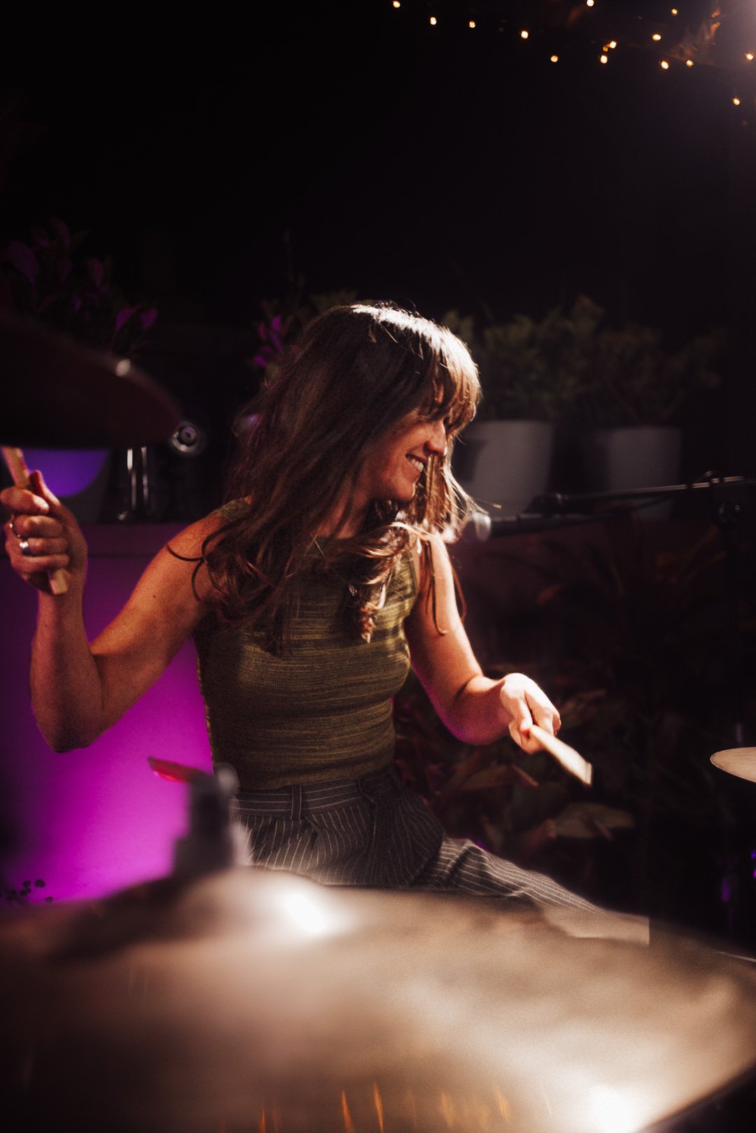 The Buoys drummer smiling while playing drums during the live Mood on the Roof performance.