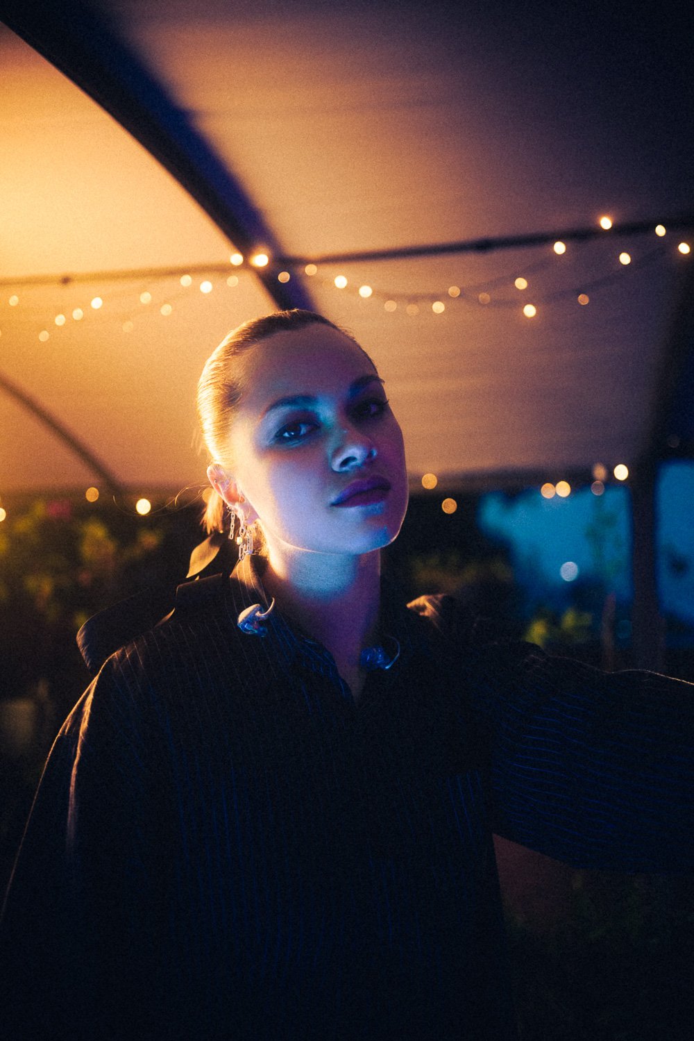 RIIKI REID under the canopy with soft blue and warm lighting