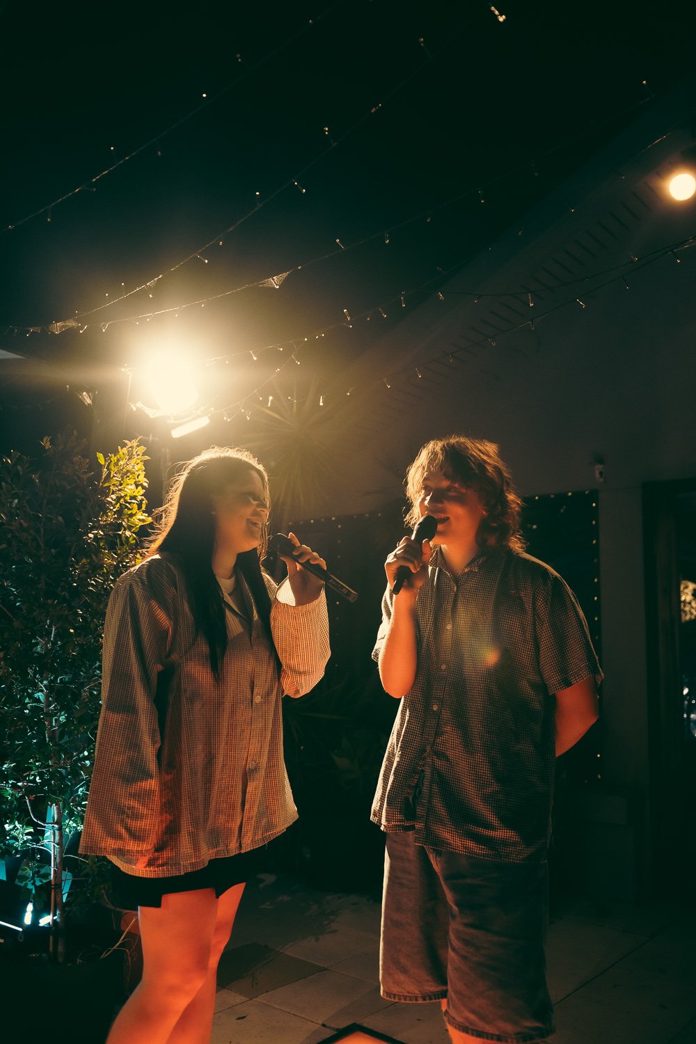 Caroline and Claude singing together on the rooftop stage.