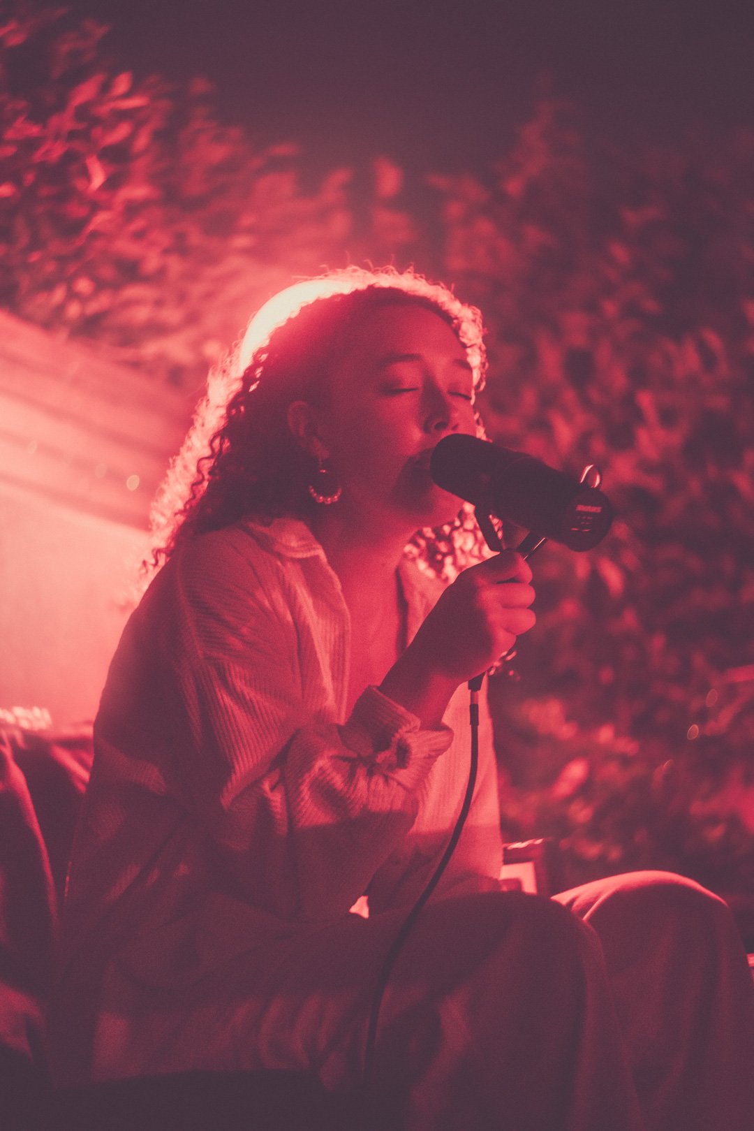 Ruby Jackson seated, eyes closed, singing with deep focus and emotional intensity.