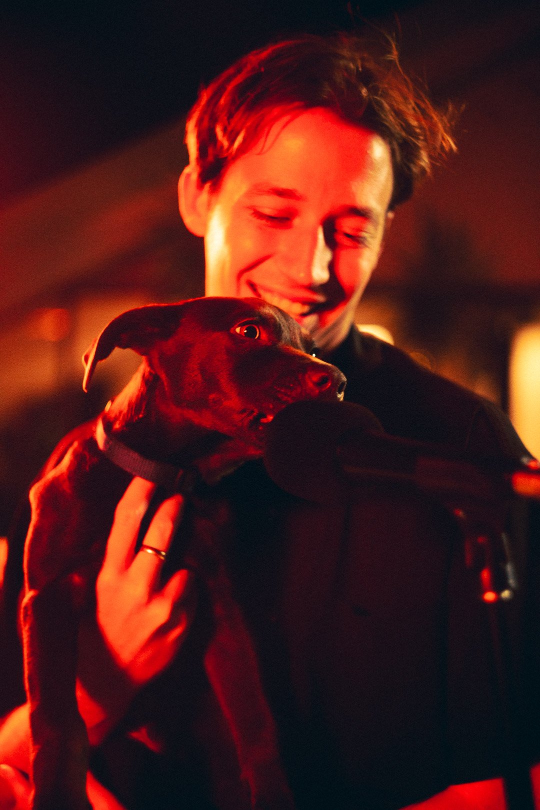 Edward Quinn smiling while holding a dog close to the microphone on the rooftop.