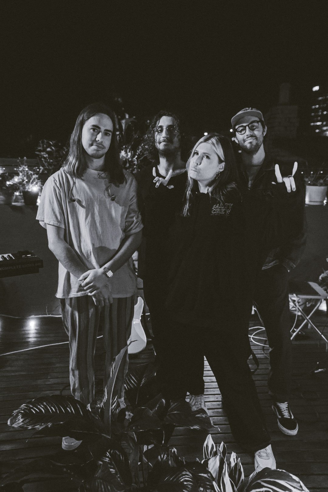 Abby Bella May posing with her live band after a rooftop performance at night